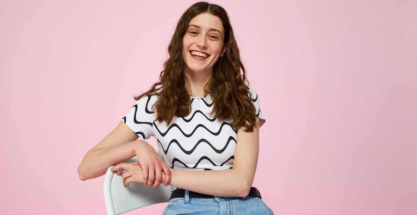 A female colleague sitting on a chair with a big happy smile on her face.jpg