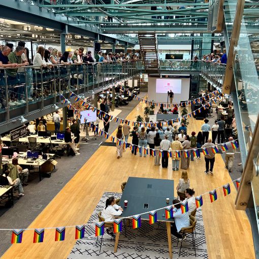 An event and presentation at the Skyways head office, with pride flags in the foreground.