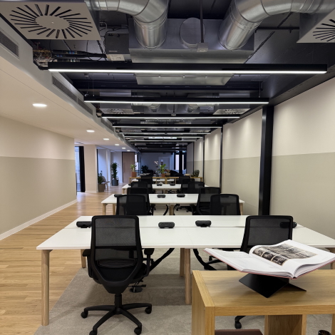 Interior photograph of the London office with desks against a white backdrop