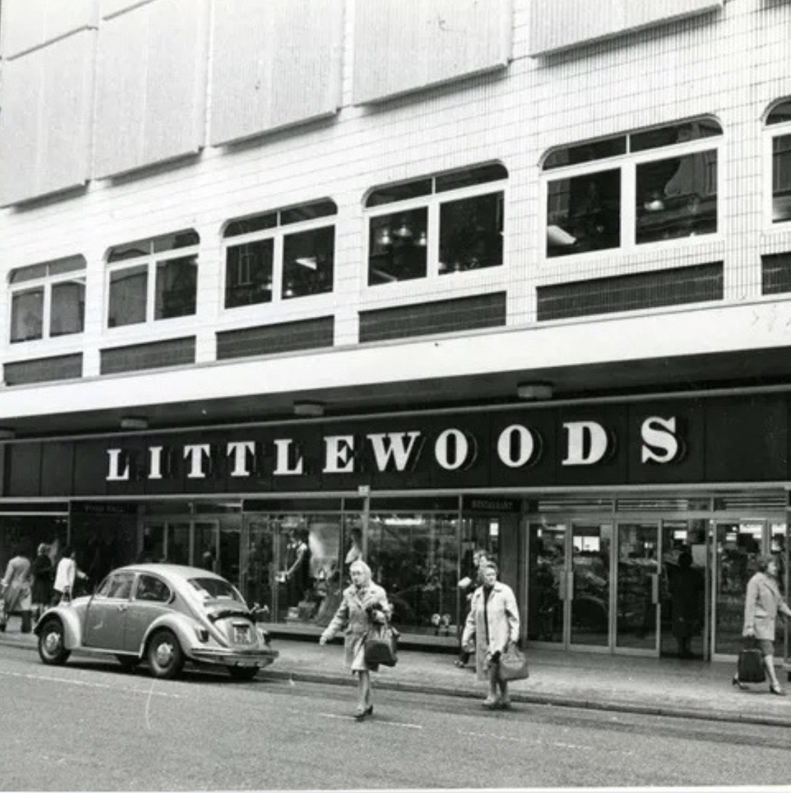 A black and white photo of a Littlewoods store front